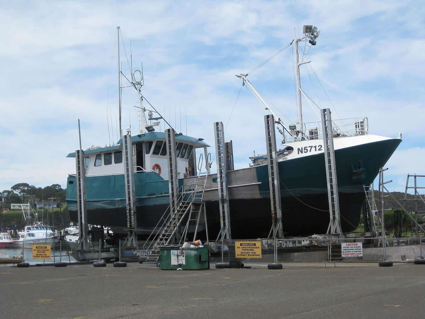 A fishing boat hauled out on stands on a boatyard hardstand