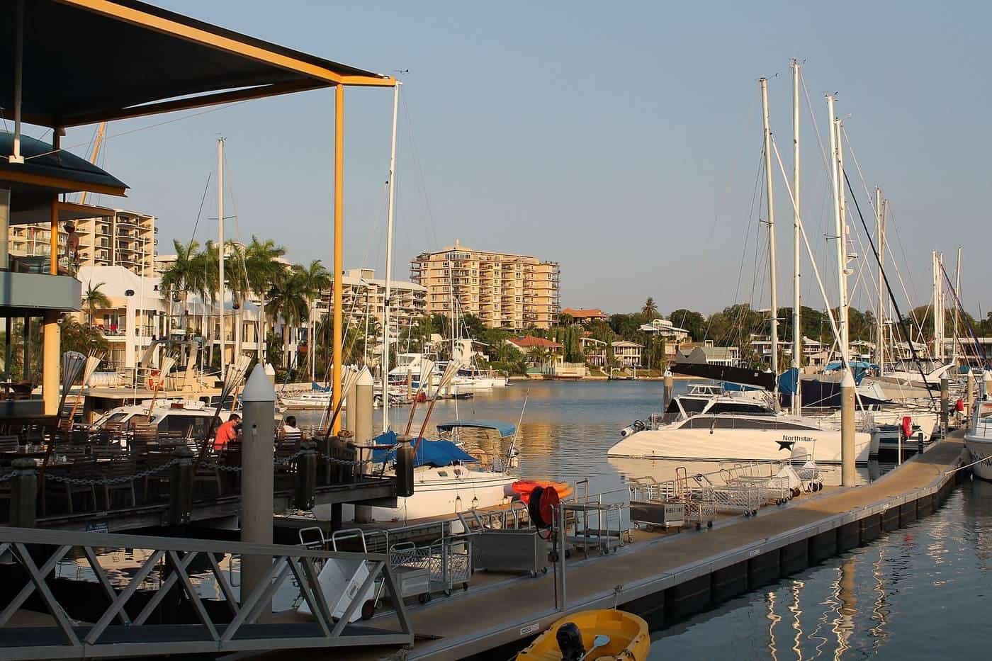 Yachts and motor cruisers tied up at pontoons in a tropical marina
